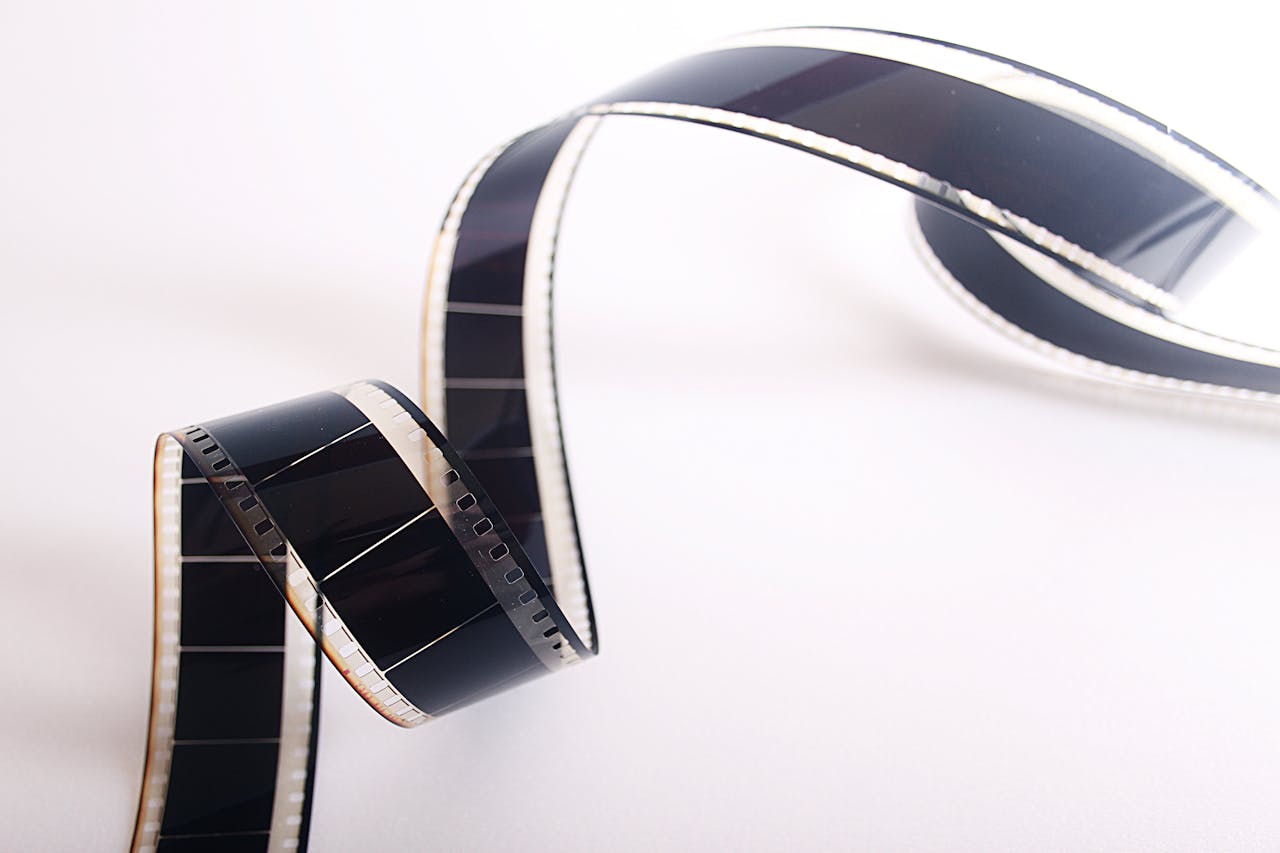 our-services-2 Close-up of a curled filmstrip against a white background, emphasizing vintage cinema.